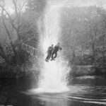 Commandos cross a river on a 'toggle bridge' at the Commando training depot at Achnacarry Scotland 1943